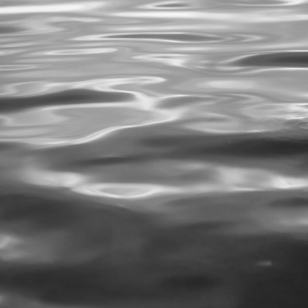 Abstract silhouette of a man in a meditative pose, with soft light lines suggesting energy flow.
